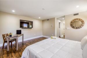 - une chambre avec un grand lit blanc et un bureau dans l'établissement Mid-Century Modern Oasis, à Miami