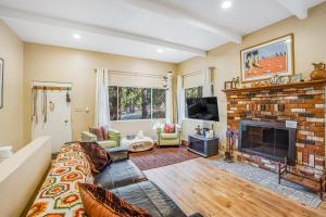 a living room with a fireplace and a tv at Meadow Creek House in Idyllwild