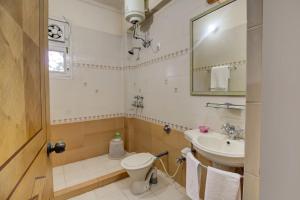 a bathroom with a toilet and a sink and a mirror at FabHotel Pinjore Holiday Home in Pinjaur