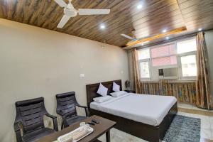 1 dormitorio con 1 cama, mesa y sillas en FabHotel Pinjore Holiday Home, en Pinjaur