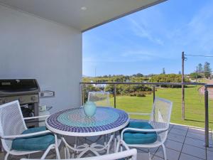 een patio met een tafel en stoelen op een balkon bij 3 The Pier on The Myall River in Tea Gardens