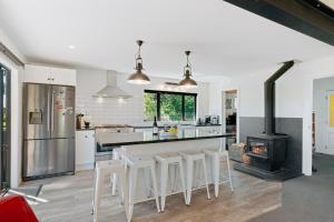 a kitchen with a stove and some white cabinets at Views on Parry - Lake Hāwea Holiday Home in Lake Hawea
