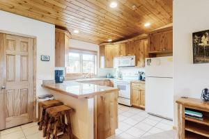 een keuken met houten kasten en een witte koelkast bij Bald Mountain Views in Grand Lake