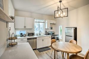 a kitchen with white cabinets and a table and a dining room at Cozy Eclectic Home about 1 Mi to Downtown Spokane in Spokane