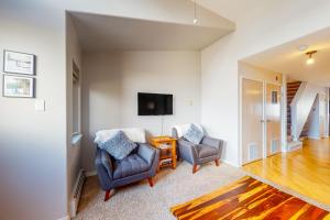 a living room with two chairs and a tv at At the Crossroads in Frisco