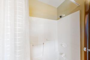 a white bathroom with a shower and a toilet at At the Crossroads in Frisco