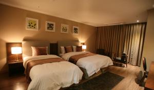 a hotel room with two beds and a window at Hyunjin Tourist Hotel in Donghae +51 photos