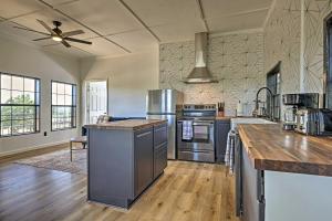 Il comprend une grande cuisine avec des appareils en acier inoxydable et du parquet. dans l'établissement Chic Fredericksburg Retreat - Near Wineries!, à Tivydale