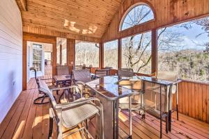 una veranda riparata con sedie e tavoli su una terrazza in legno di Large Lake Cumberland Retreat with Deck Views! a Jamestown