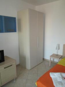 1 dormitorio con armario, cama y mesa en Residence la Piazza, en Santa Maria