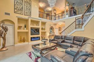 a living room with a leather couch and a table at Lavish Escape with Game Room - 20 Mi to Beach! in Palm Beach Gardens