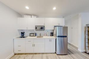 uma cozinha com armários brancos e um frigorífico de aço inoxidável em The Cubby at Prospector em Park City