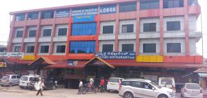 a large building with cars parked in front of it at STAYMAKER Pushpagiri Comforts in Sakleshpur