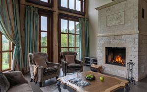 a living room with a fireplace and a table and chairs at Cosmos Collection Altay Resort in Urluaspak