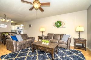 a living room with two couches and a ceiling fan at Cedar Lodge in Pigeon Forge