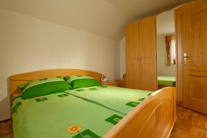 a bedroom with a green bed with green pillows at Vineyard Cottage Ucman in Otočec