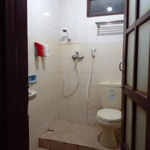 a bathroom with a toilet and a shower in it at Hotel Bifa Yogyakarta in Yogyakarta