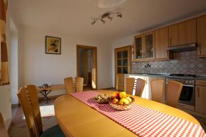 una cocina con una mesa con un bol de fruta. en Vineyard Cottage Ucman, en Otočec