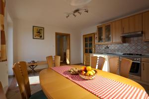 a kitchen with a table with a bowl of fruit on it at Vineyard Cottage Ucman in Otočec