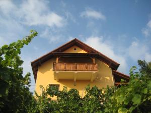 a yellow building with a balcony on top of it at Vineyard Cottage Ucman in Otočec