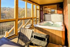 a room with a tub and a chair on a balcony at 3 Lazy Bears Chalet in Gatlinburg