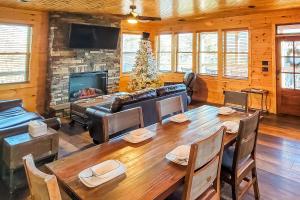 a living room with a large wooden table and a fireplace at 3 Lazy Bears Chalet in Gatlinburg