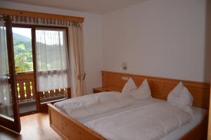キエーネスにあるFalkenauのベッドルーム1室(白いシーツ付きのベッド1台、窓付)