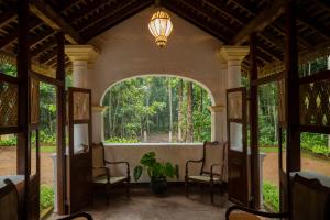 un arco en una casa con sillas y una planta en Gileemale Walawwa & Estate en Ratnapura