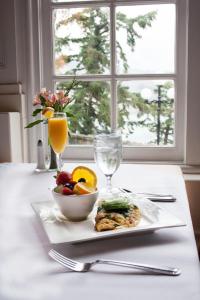 a plate with a bowl of fruit and a glass of orange juice at Columbia Gorge Hotel & Spa in Hood River