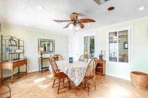 a dining room with a table and chairs and a ceiling fan at Pelican House in Saint Joe Beach