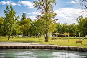 a park with a body of water and trees at Balatontourist Berény Naturist Camping in Balatonberény