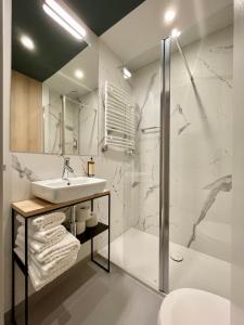 a white bathroom with a sink and a shower at Wilanów Residence Apartments in Warsaw +108 photos