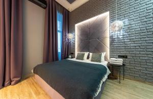 a bedroom with a bed and a brick wall at Tomas apartments in Kyiv
