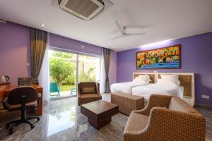 um quarto de hotel com uma cama, uma secretária e cadeiras em Boutique Villa Bougainvillea em Weligama