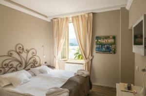 a bedroom with a large bed and a window at Relais Villa Porta in Luino