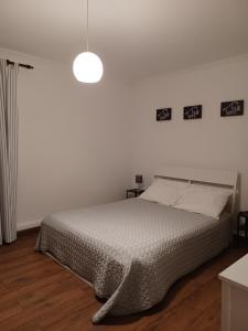 a bedroom with a bed and a light fixture at De Cá - suite com acesso independente e kitchenette in Lousã