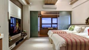 溫朵莉 Wendoly's Hot Spring Suite في تاتشينج: غرفة فندقية بسريرين وتلفزيون بشاشة مسطحة