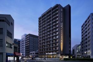 a tall building in a city with buildings at Hotel New Port Yokosuka in Yokosuka