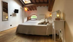 a bedroom with a white bed and white walls at L'Albero Di Gamelì in Chiusi