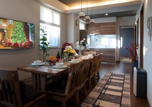 a dining room with a long wooden table and chairs at Miidokoro House Hotel in Sapporo