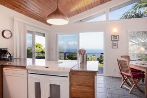 a kitchen with a view of the ocean at Waipio Glass House in Kukuihaele