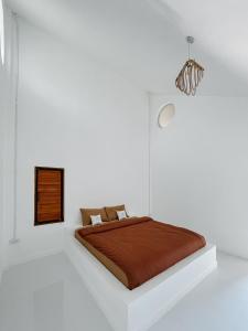 a white bedroom with a bed with a brown blanket at Aether Pai Villa in Pai