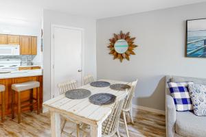 a dining room with a table and a kitchen at Harbour Place 108 in Gulf Shores