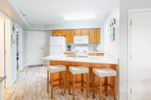 a kitchen with wooden cabinets and white appliances at Harbour Place 108 in Gulf Shores