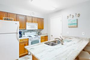 a kitchen with a sink and a white refrigerator at Harbour Place 108 in Gulf Shores +25 photos