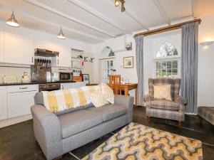een woonkamer met een bank en een keuken bij Destiny Cottage in Boscastle