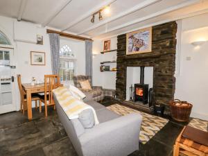 a living room with a couch and a fireplace at Destiny Cottage in Boscastle