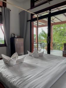 a white bed with two white pillows on it at Villa Vedici in Kampot