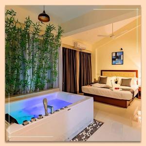 a room with a bath tub with a bed and a bedroom at Hotel Reemz Beach Heaven , Anjuna in Anjuna