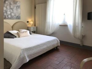um quarto com uma grande cama branca e uma janela em L'Albero Di Gamelì em Chiusi